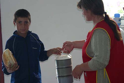 Junge bringt das Essen von der Kche zu einer betagten Person